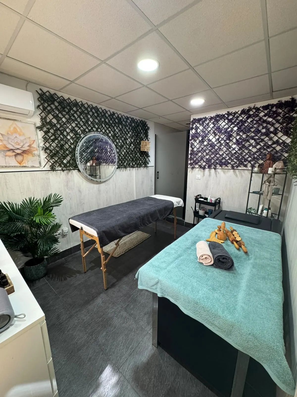 Sala de masajes del estudio: dos camillas preparadas, plantas, espejo y luz cálida